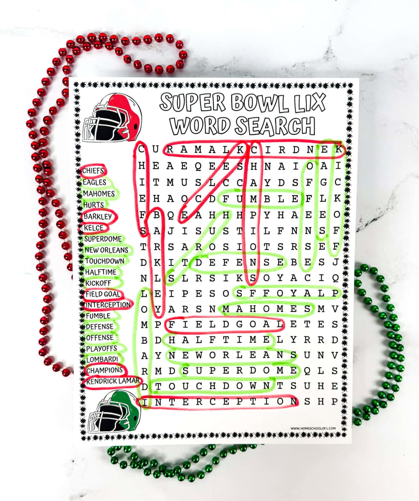 A completed Super Bowl LIX word search puzzle with all words found and highlighted in red and green. The word list includes terms like Chiefs, Mahomes, Superdome, Touchdown, Field Goal, Interception, and Kendrick Lamar. The page is decorated with red and green football helmets and surrounded by matching beaded necklaces on a white marble surface.