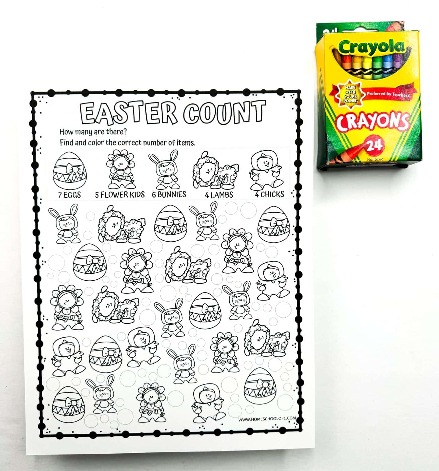 Black and white Easter counting worksheet titled “Easter Count,” featuring illustrations of eggs, flower kids, bunnies, lambs, and chicks. Children are instructed to find and color the correct quantity of each item listed at the top. A 24-pack of Crayola crayons is placed on the upper right side of the worksheet.