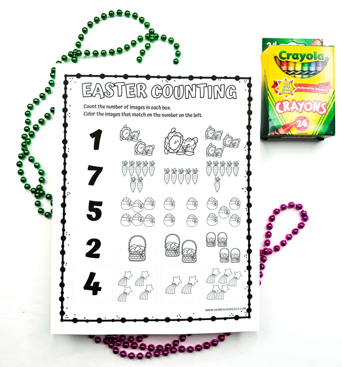 Printable Easter counting worksheet featuring rows of themed images like lambs, carrots, eggs, baskets, and rainbows, with large numbers on the left column (1, 7, 5, 2, 4) for kids to match and color. Green and pink beaded necklaces frame the paper, and a box of 24 Crayola crayons sits at the top right.
