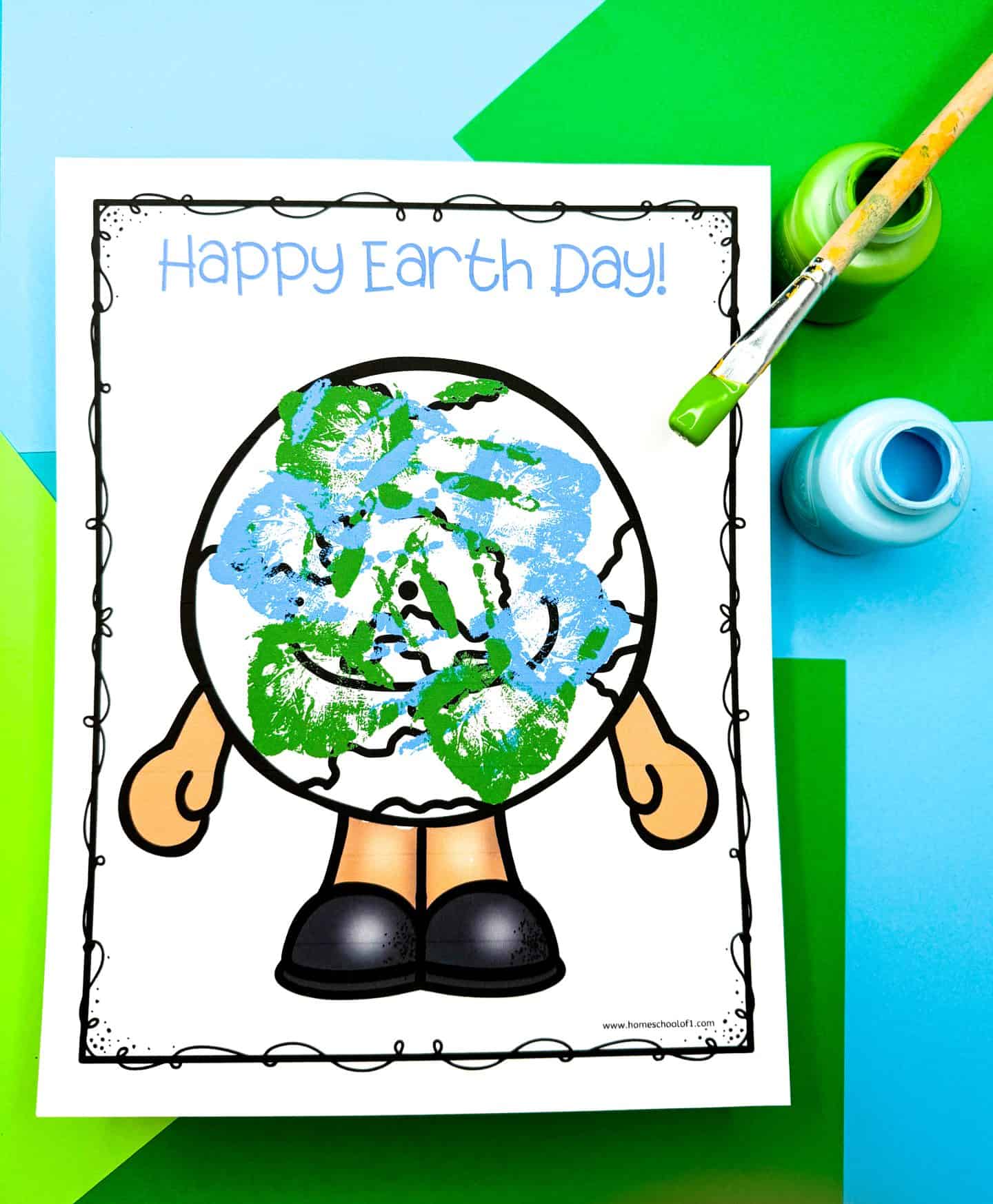 Earth Day handprint craft showing a globe character with blue and green painted handprints filling in the continents and oceans. The top reads “Happy Earth Day!” in light blue, and the printable sits on a green and blue paper background with open green and blue paint jars and a paintbrush nearby.

