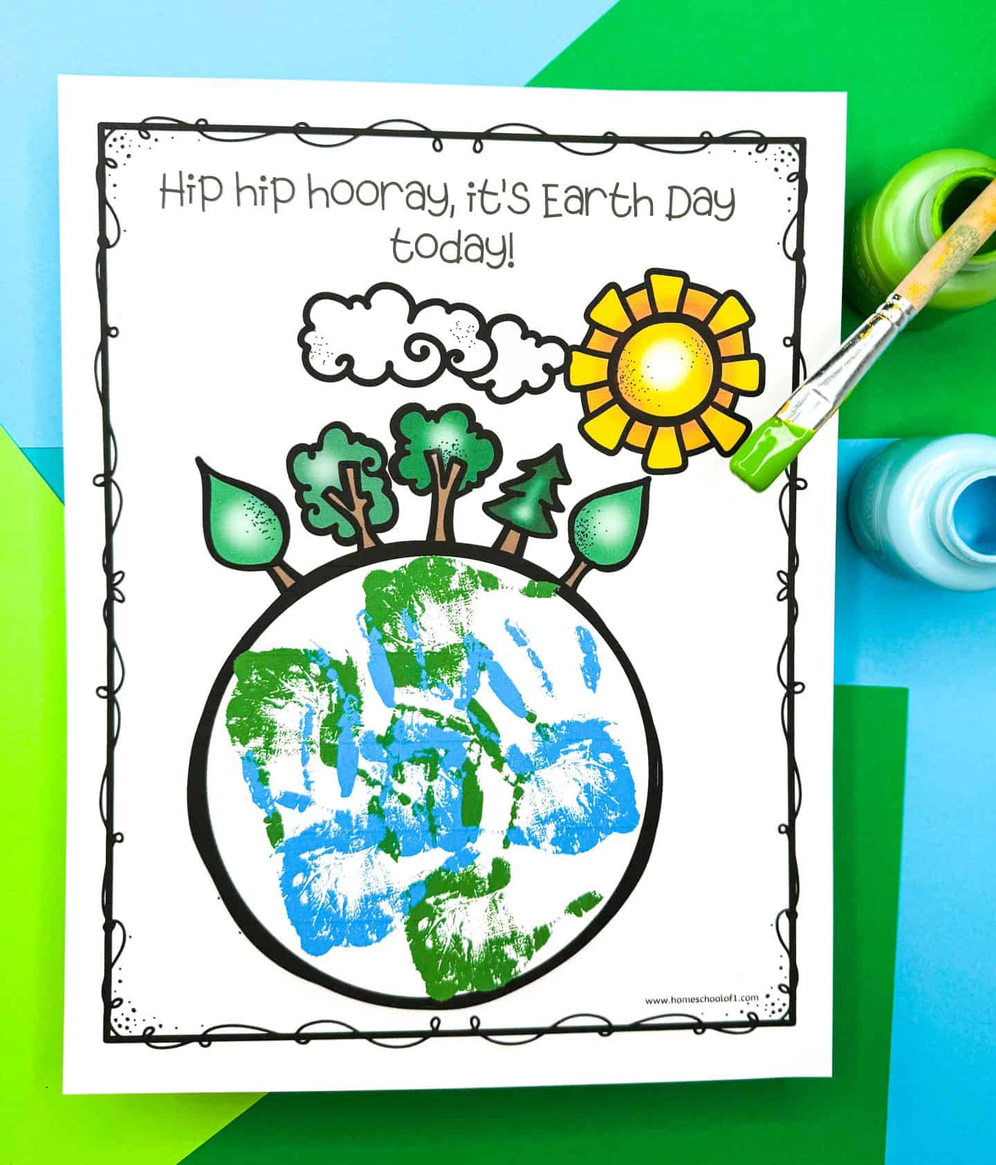 Earth Day handprint art featuring a globe outlined in black with blue and green handprints filling in the continents and oceans. The top of the page reads “Hip hip hooray, it’s Earth Day today!” and illustrations of trees, leaves, a cloud, and a bright yellow sun sprout from the top of the Earth. Set against a vibrant green and blue paper background with open paint jars and a paintbrush with green paint.

