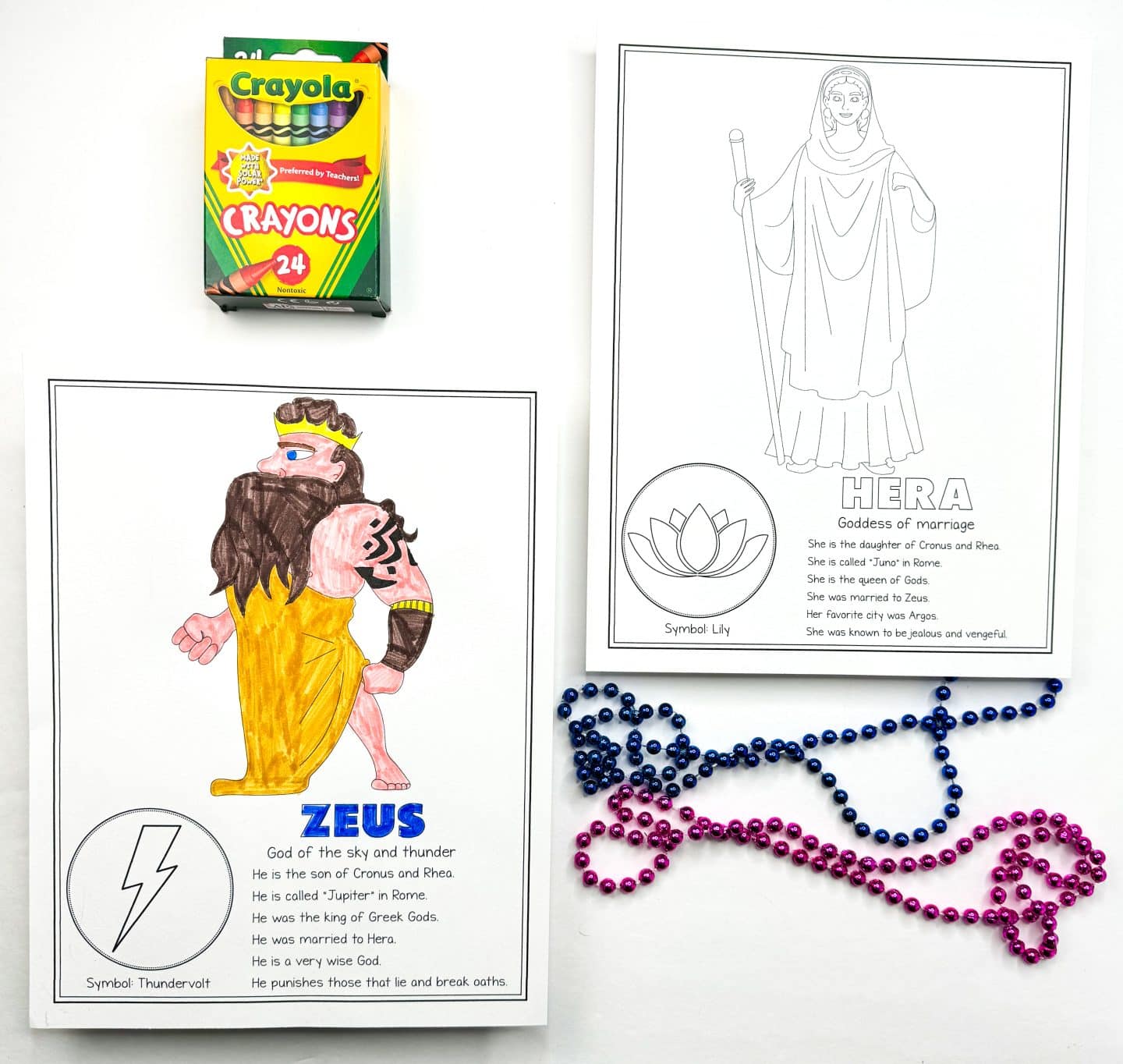 a coloring page of Zeus, colored in, with a description of his role as the God of the sky and thunder. Next to it is an uncolored page of Hera, the Goddess of marriage, with a description of her background. Crayola crayons and purple and pink beads are placed in the frame.