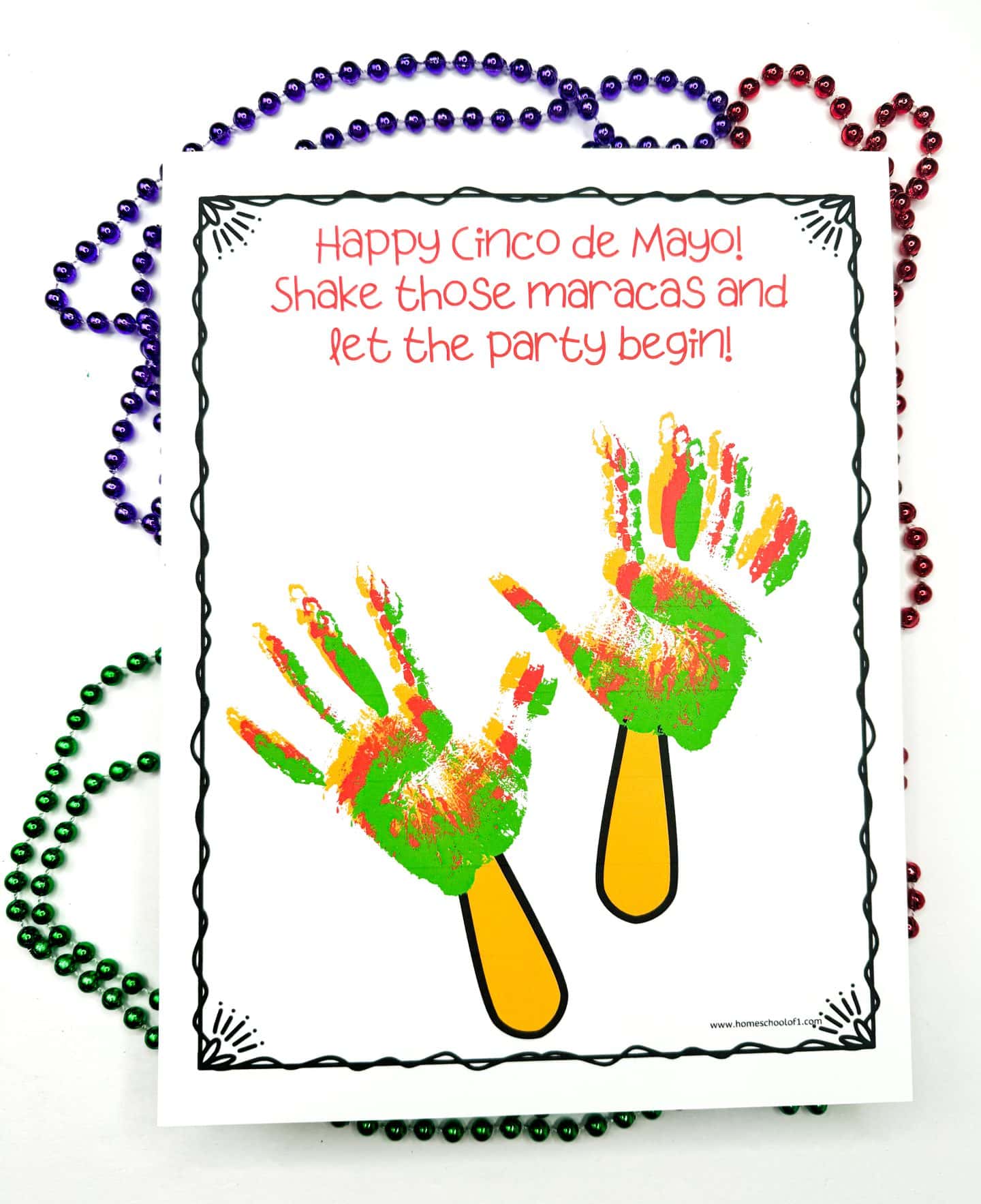 A vibrant handprint art piece depicting maracas, with the text "Shake it up!" emphasizing the festive spirit of Cinco de Mayo.