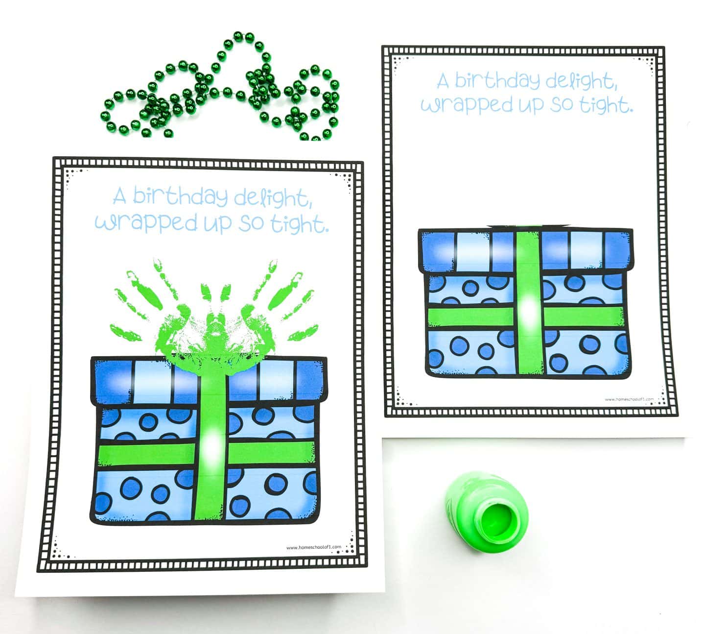 Printable birthday craft showing a blue gift box with green ribbon and polka dots, accompanied by the phrase “A birthday delight, wrapped up so tight.” One sheet features green handprints above the box, while the other is blank, ready for decoration. Green beads and a bottle of green paint are also visible.