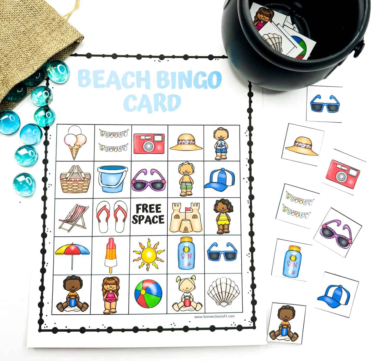 Colorful Beach Bingo printable card featuring fun summer-themed icons like a beach ball, sunglasses, flip-flops, ice cream, sunscreen, and a sandcastle. The card is paired with matching cut-out calling pieces, blue glass markers, a burlap bag, and a black container for drawing tiles. Title at the top reads “BEACH BINGO CARD” in light blue.

