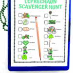 Leprechaun scavenger hunt printable on a clipboard with checklist items like rainbow, shamrock, emerald, potato, and leprechaun, plus a pencil and green beads for St Patrickโs Day.