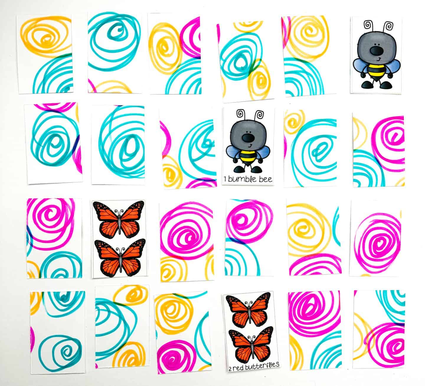 A colorful matching card game featuring swirly pattern backs in teal, yellow, and pink. Some cards are flipped to reveal illustrations: a cartoon bumblebee with the label "1 bumble bee," and red butterflies with the label "2 red butterflies." The game appears to be designed for young children, likely to help with counting or matching.