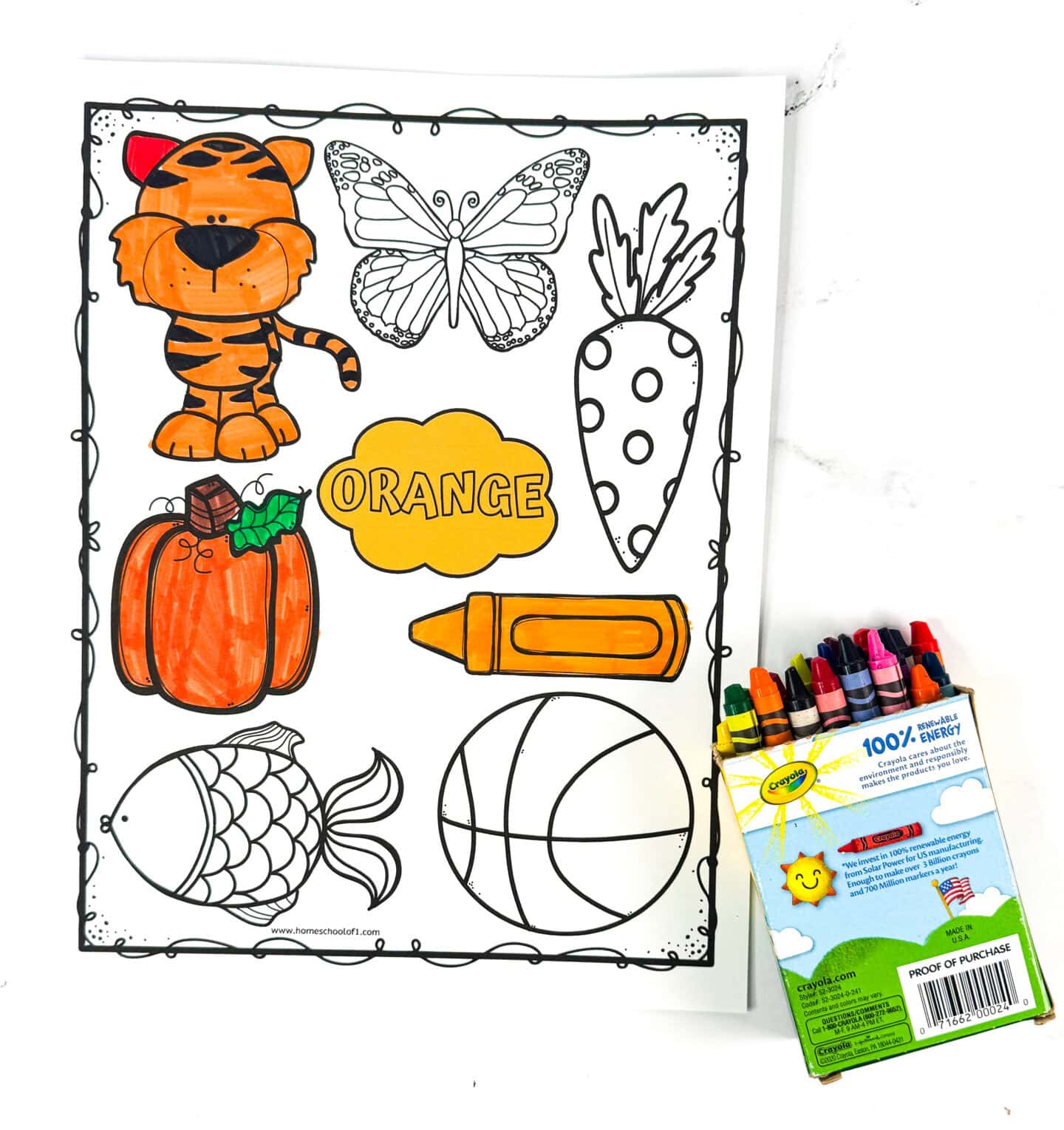 An orange color printable features outlined drawings of a tiger, butterfly, carrot, pumpkin, crayon, fish, and basketball, with some images partially colored in orange. A cloud in the center is labeled orange, and a Crayola crayon box with crayons spilling out sits on the right. The activity is designed to help young children recognize and associate objects with the color orange.