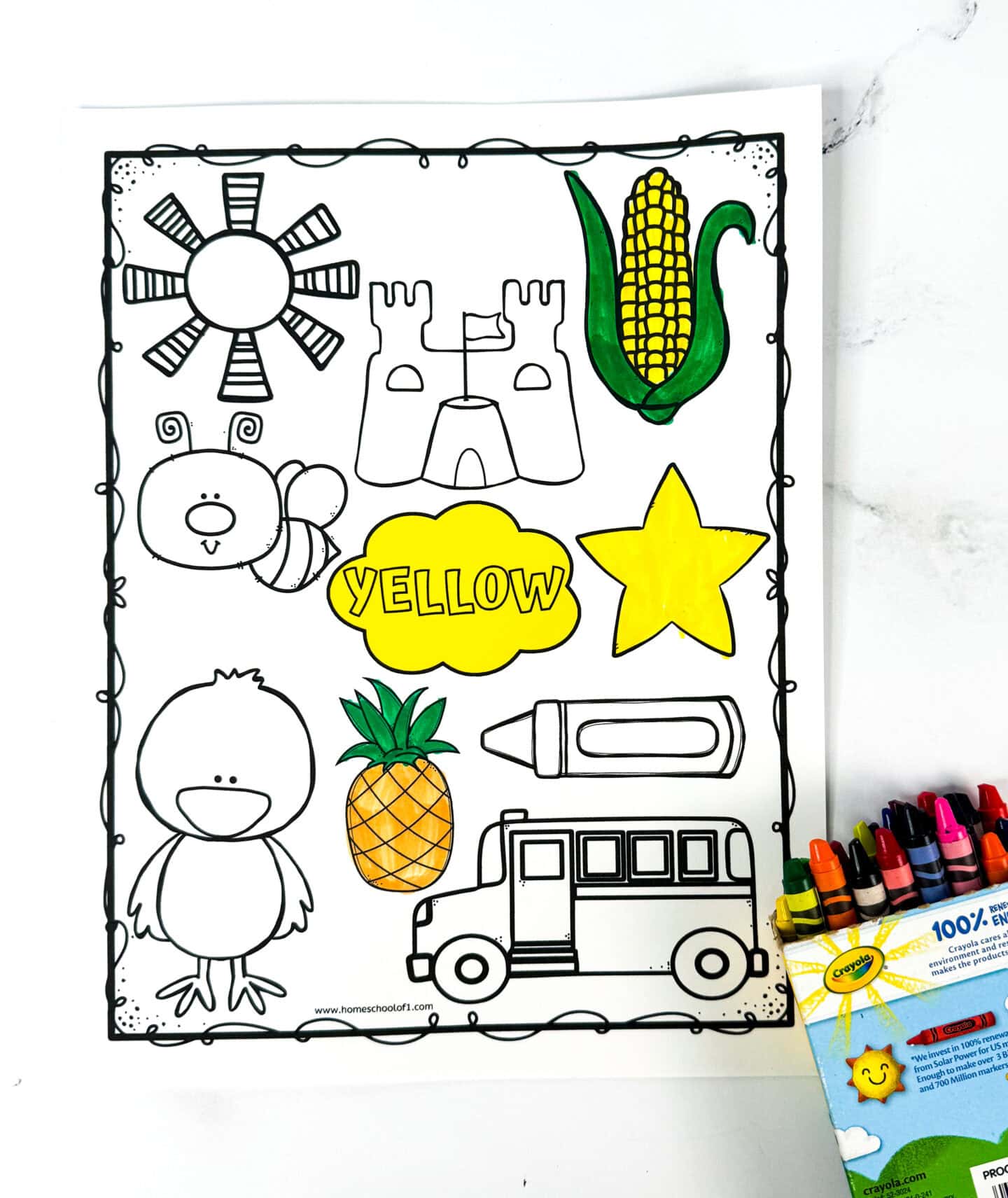 A yellow color worksheet displays outlined drawings of a sun, sandcastle, corn, star, chick, pineapple, crayon, and a school bus, with some items partially colored yellow. The center features a yellow cloud shape labeled yellow. A Crayola crayon box with crayons sticking out is placed to the side, and the activity encourages young children to recognize and color objects associated with the color yellow.