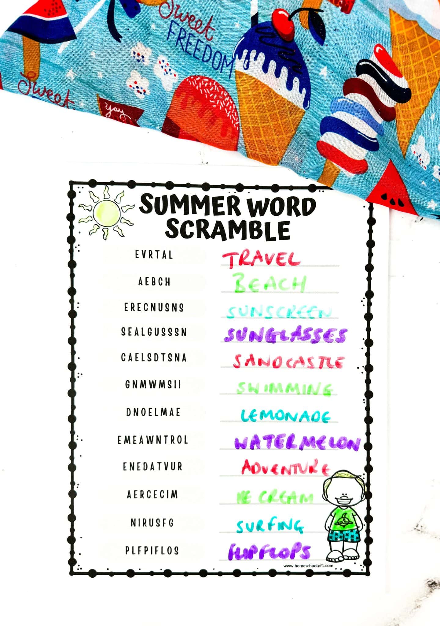 A colorful summer word scramble worksheet filled in with answers written in various bright marker colors. The scrambled words are matched with answers like Travel, Beach, Sunscreen, Sunglasses, Sandcastle, and more. A cheerful fabric with ice cream cones, popsicles, and the words “Sweet Freedom” appears in the background, adding a festive summer vibe.