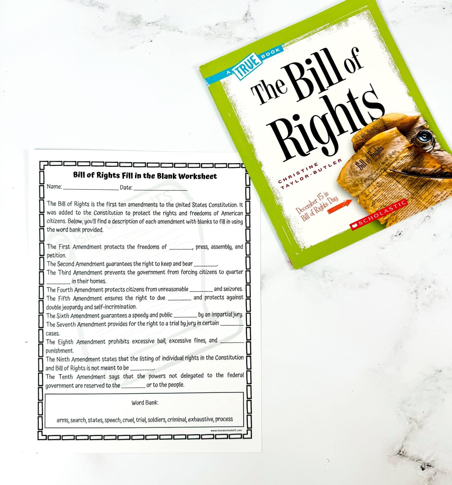 A “Bill of Rights Fill in the Blank Worksheet” is laid out on a white surface next to a Scholastic book titled The Bill of Rights by Christine Taylor-Butler. The worksheet lists ten amendments with blank spaces to fill in key concepts like “speech,” “arms,” and “trial,” guided by a word bank at the bottom. The book has a green cover and features an image of a rolled-up parchment with the U.S. Constitution on it, promoting Bill of Rights Day on December 15.

