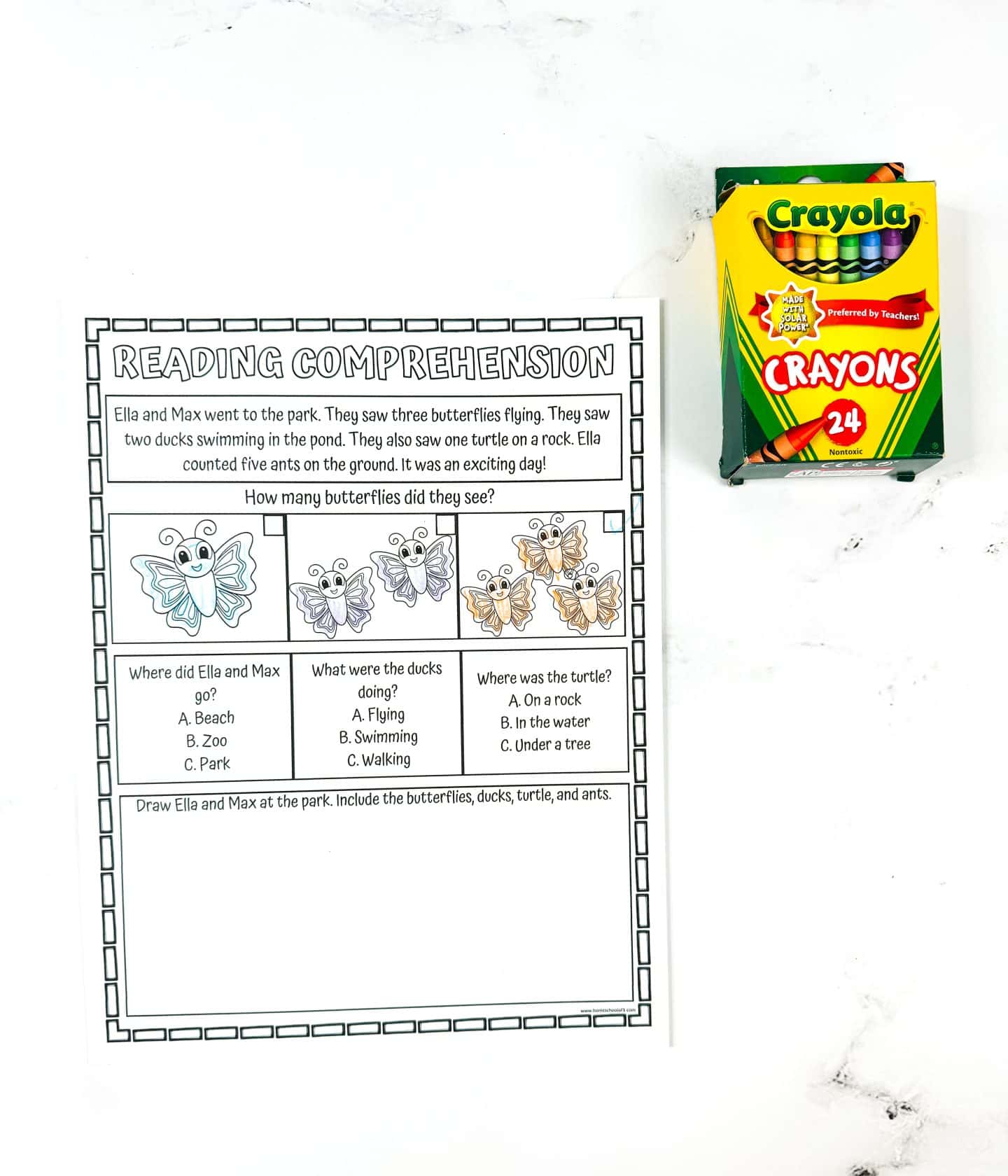 A printable summer reading comprehension worksheet for kids featuring a story about Ella and Max visiting the park, where they see butterflies, ducks, a turtle, and ants. Includes images of butterflies with a question about how many they saw, multiple-choice questions about the animals, and a drawing prompt to illustrate the scene. A box of 24 Crayola crayons sits beside the worksheet on a white marble surface.