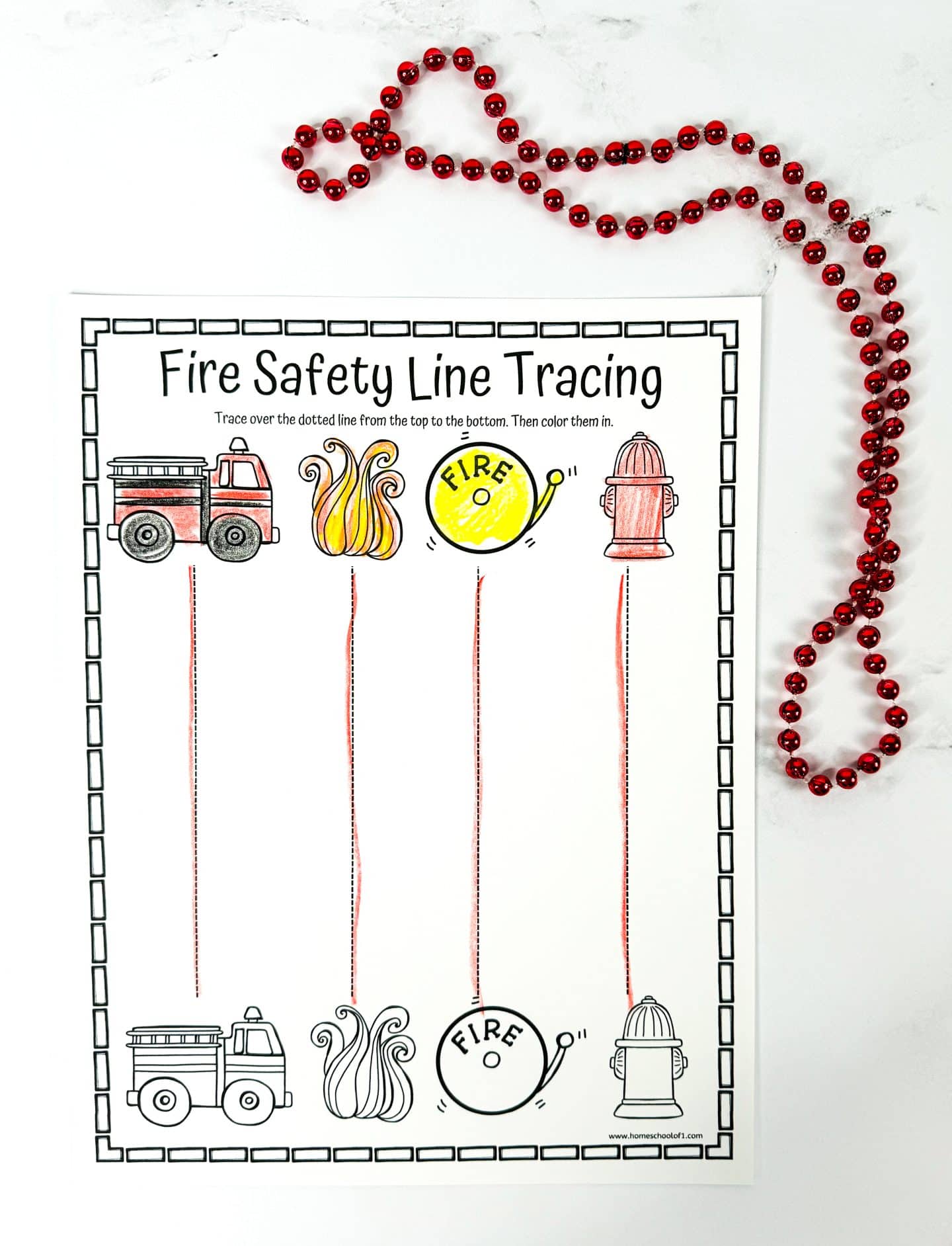 Fire safety line tracing worksheet with vertical dotted lines connecting colored images of a fire truck, flames, fire alarm, and hydrant at the top to matching black-and-white versions at the bottom. Kids trace each line and color the pictures to reinforce fire safety recognition and motor skills.
