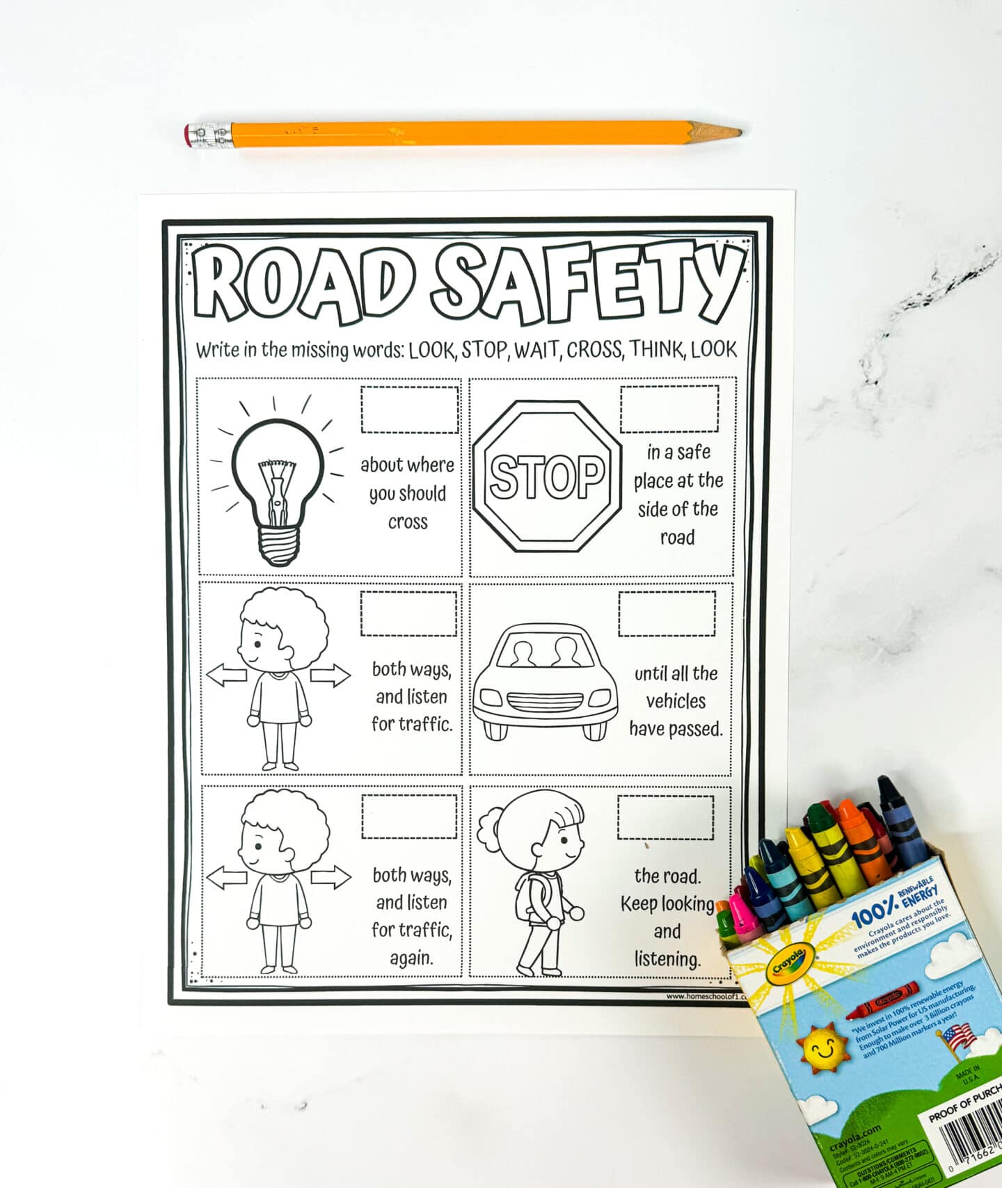 Black-and-white road safety worksheet for kids with a fill-in-the-blank activity using the words: LOOK, STOP, WAIT, CROSS, THINK. Includes illustrations like a lightbulb, stop sign, pedestrians, and a car, along with matching safety instructions such as “____ both ways and listen for traffic.” A pencil lies above the sheet, and a box of Crayola crayons is at the bottom right corner.