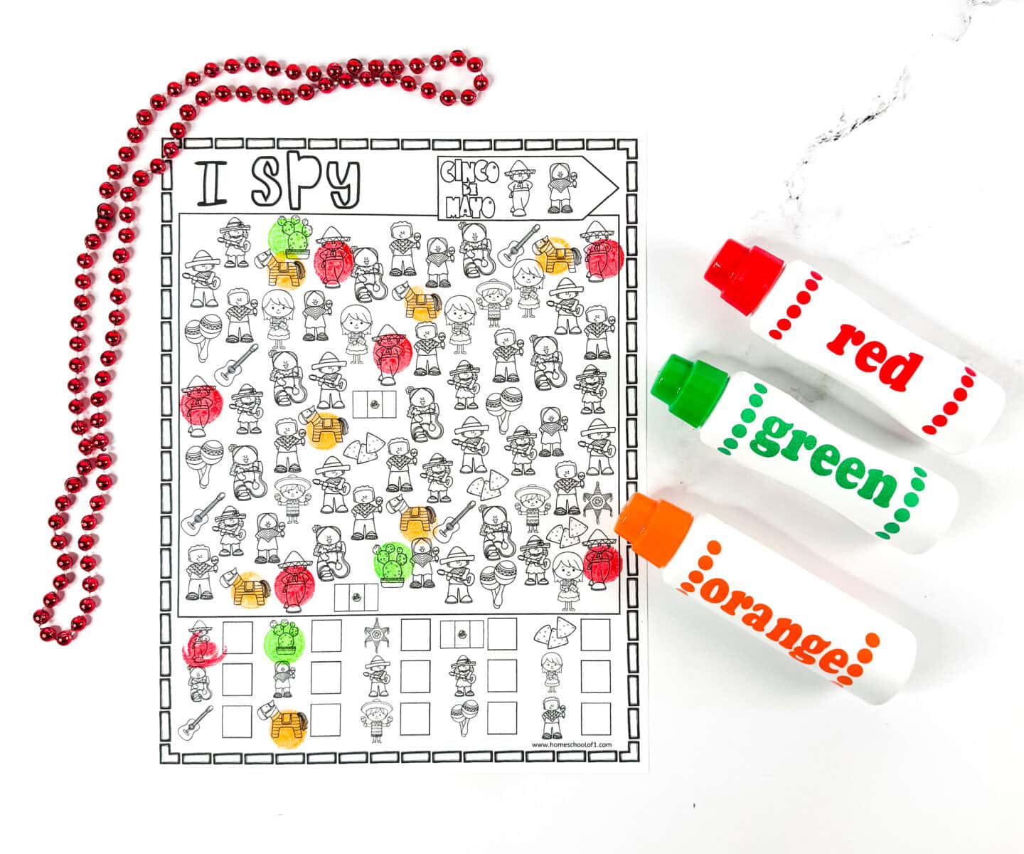 Cinco de Mayo I Spy worksheet partially marked with red, green, and orange dot markers, featuring festive icons like ponchos, piñatas, cactus plants, and chips. A hands-on, holiday-themed activity great for preschool or elementary students.