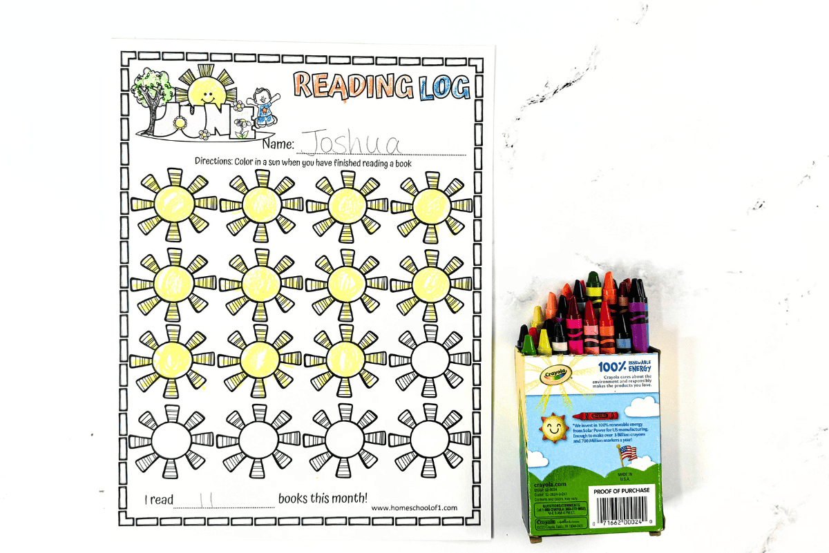 Printable June reading log for kids with Crayola crayons beside the sheet; 18 suns colored to mark finished books.
