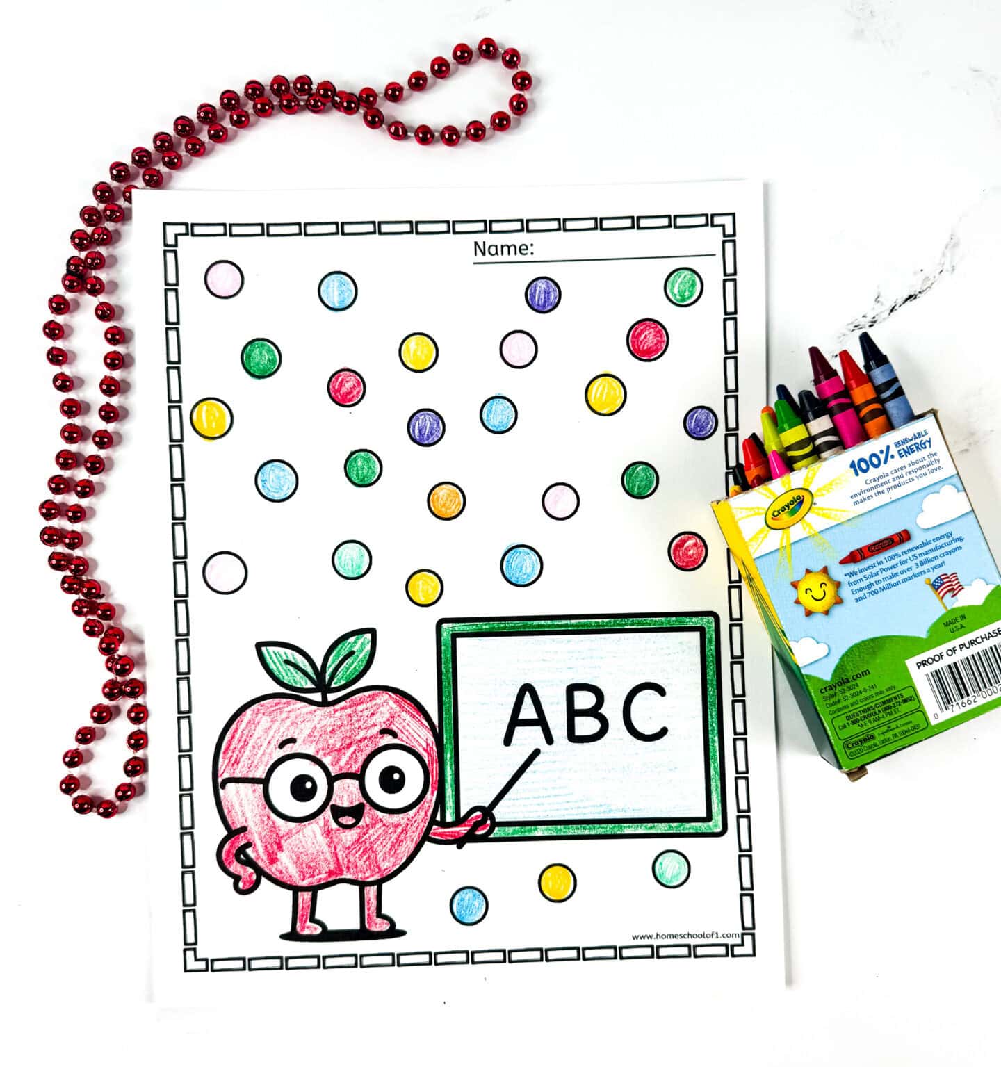 Cute apple coloring sheet featuring an apple character wearing glasses, holding a pointer at a chalkboard labeled “ABC,” surrounded by multi-colored dots filled in with crayons.