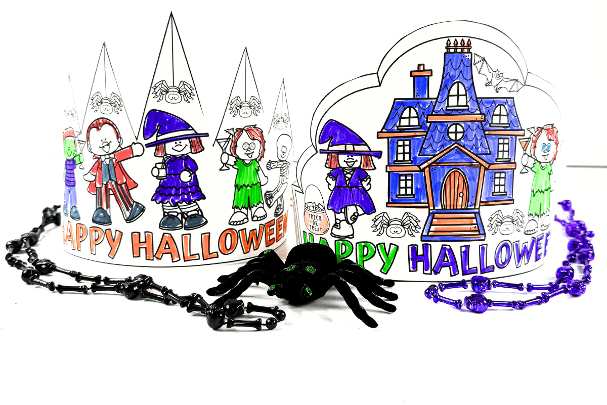 Two colored Halloween crown printables displayed with necklaces, toy spider, and bright HAPPY HALLOWEEN text designs.