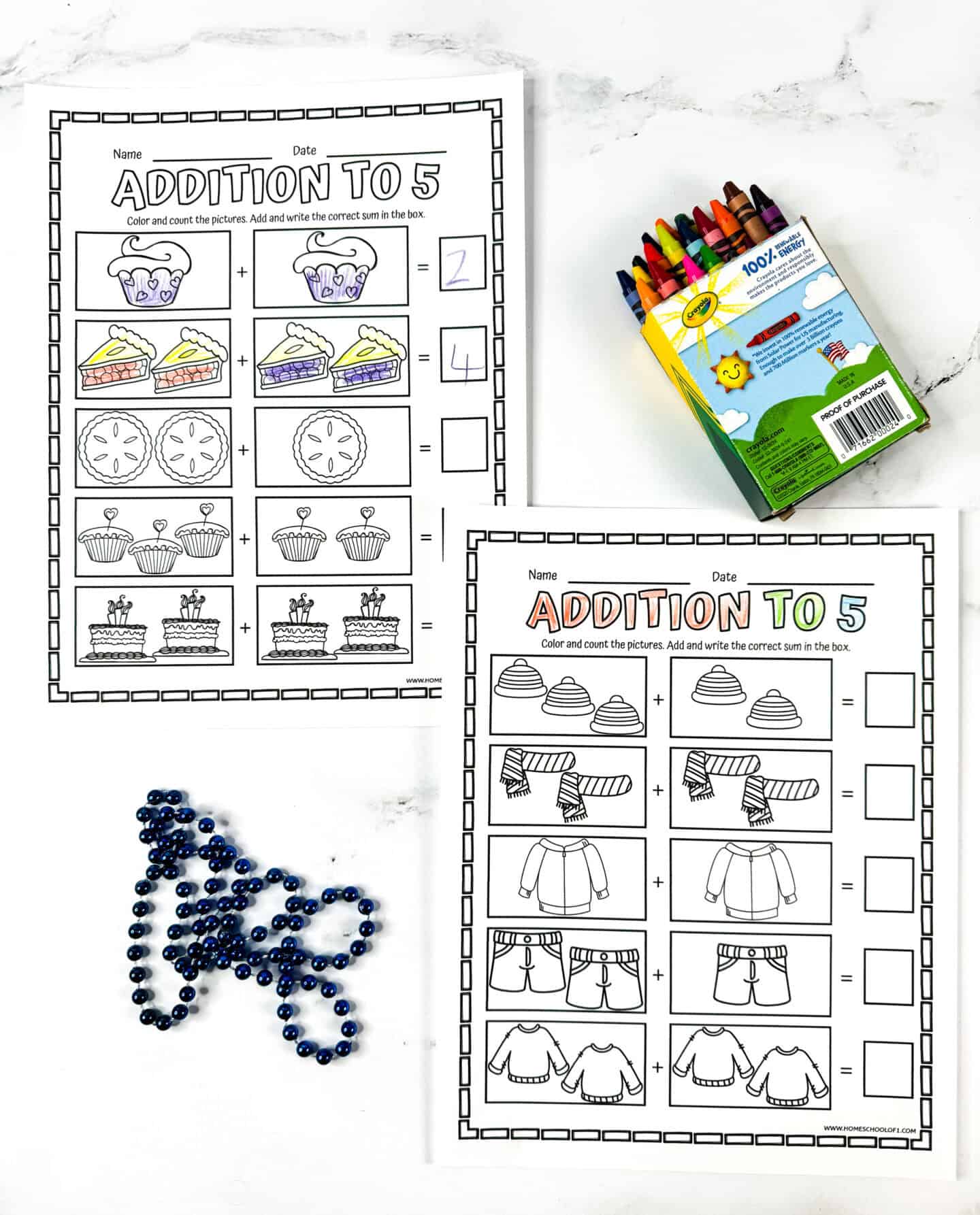 Kindergarten addition to 5 worksheets with cupcakes, cakes, and winter clothing illustrations, shown with crayons and blue beads.