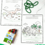 Close-up of Velociraptor and Triceratops coloring pages with crayons and green beads on a white background.