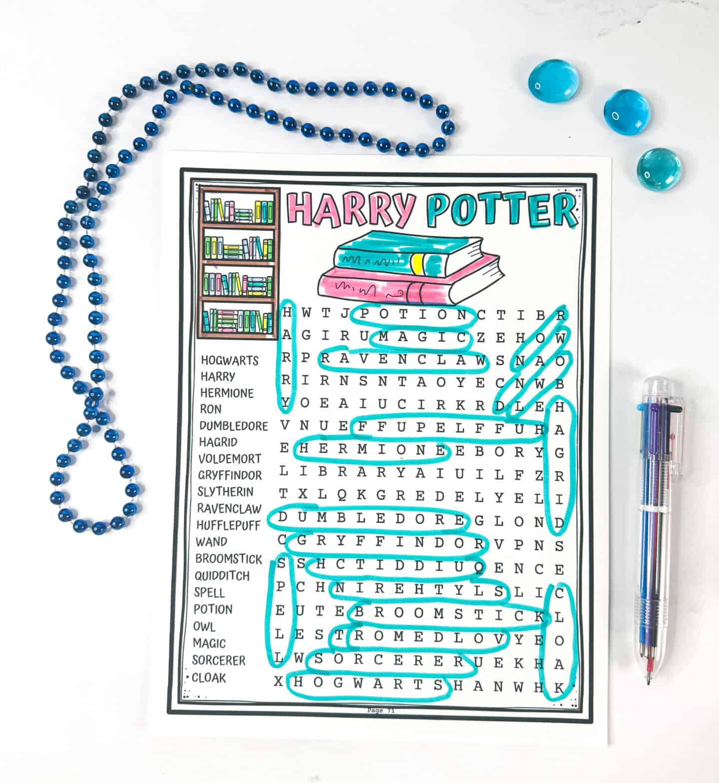Completed Harry Potter word search printable with colorful header and circled answers in teal ink. Surrounded by blue beads, glass gems, and a multi-color pen.