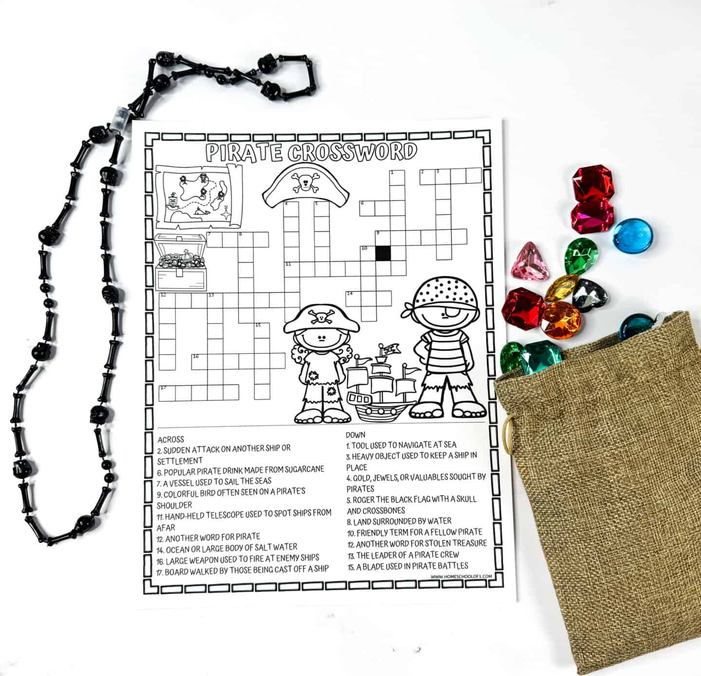 Black-and-white pirate crossword puzzle printable surrounded by pirate beads and colorful plastic gems.