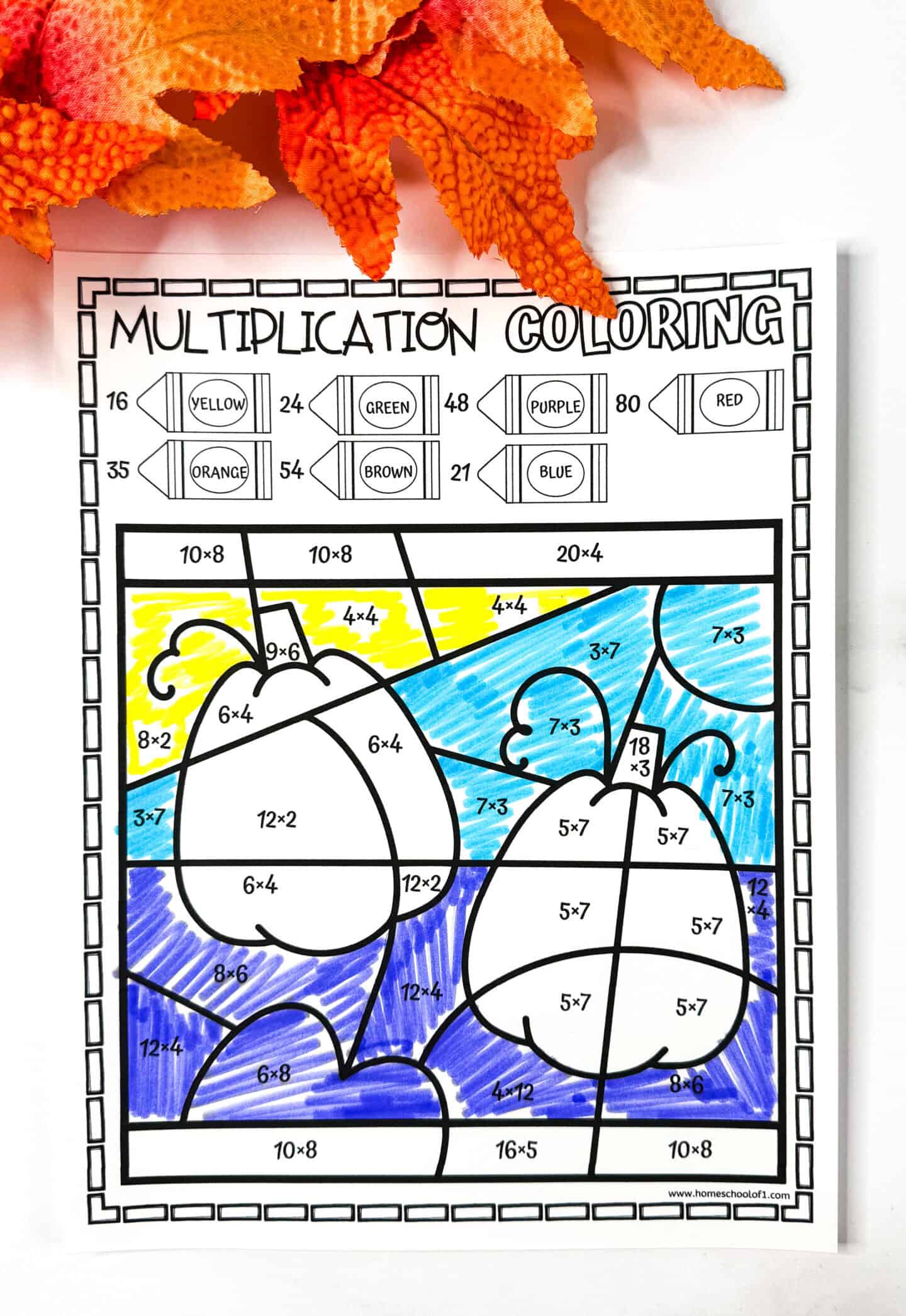 Completed multiplication color by number worksheet showing two pumpkins, revealed by solving and coloring multiplication problems.