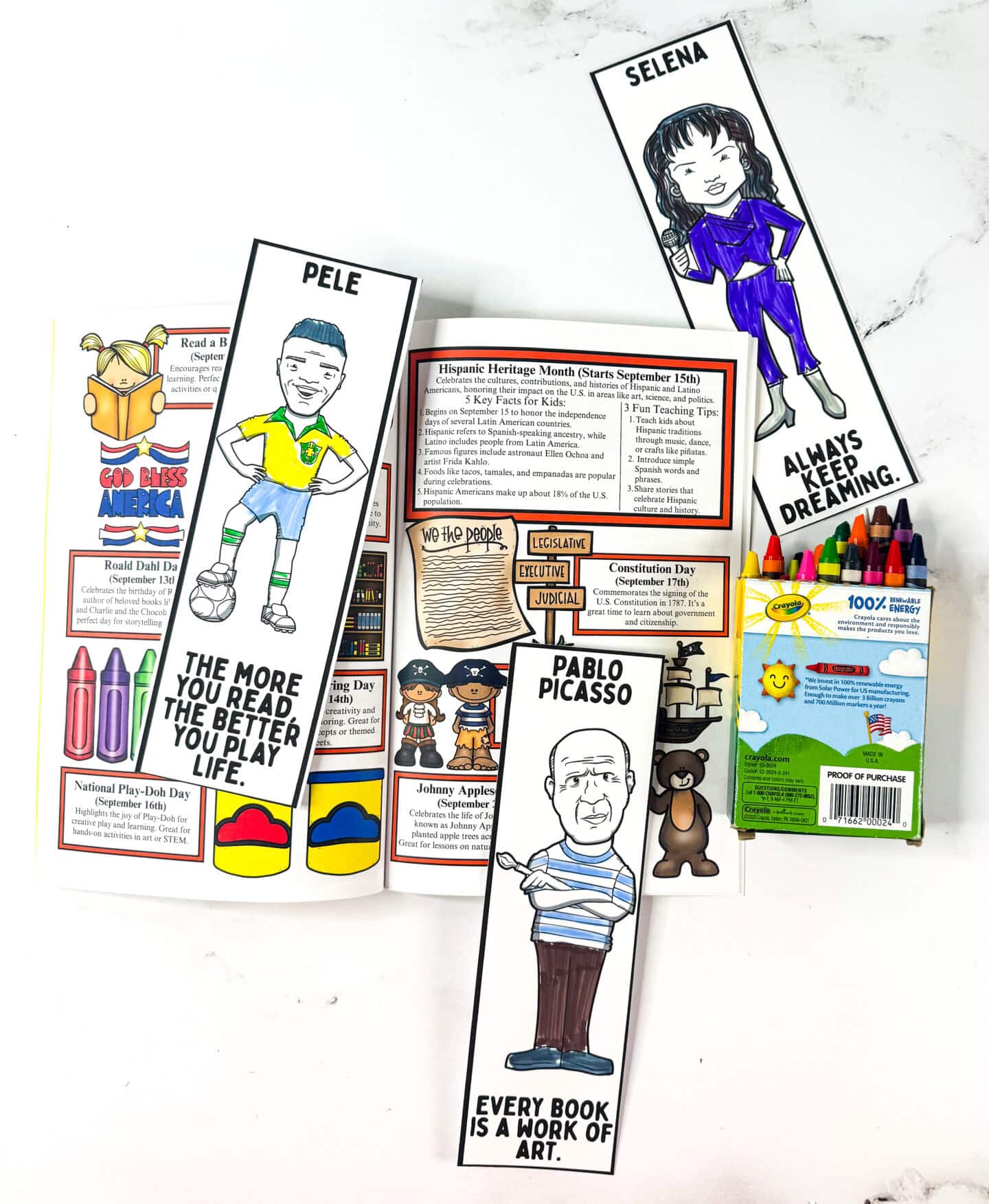 Free printable bookmarks for Hispanic Heritage Month shown inside the Teach & Celebrate the Year workbook with crayons and facts about Hispanic leaders.