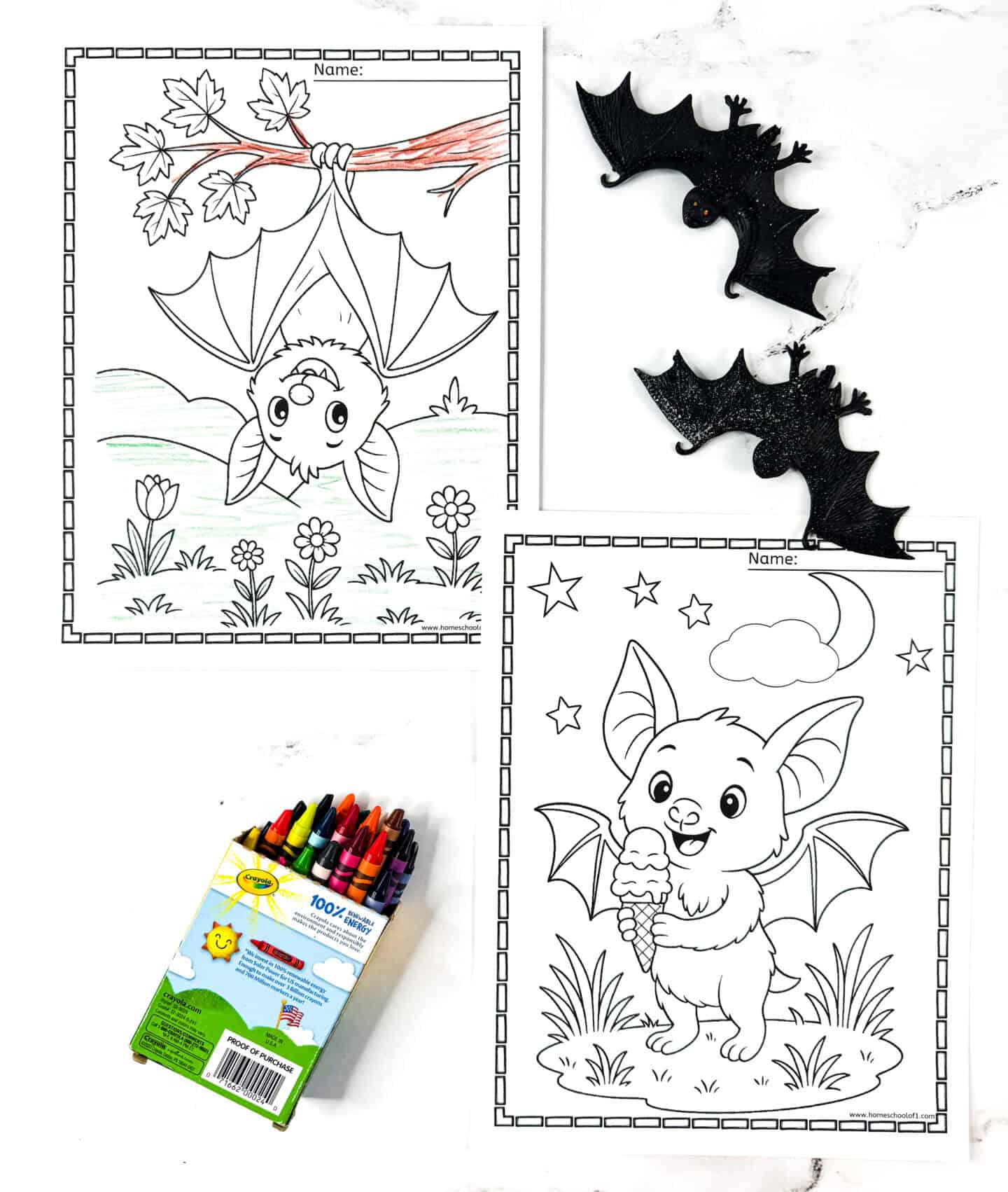 Two bat coloring pages for kids—one showing a bat hanging upside down from a tree, and the other holding an ice cream cone under a night sky. Pages are paired with plastic bat props and crayons.