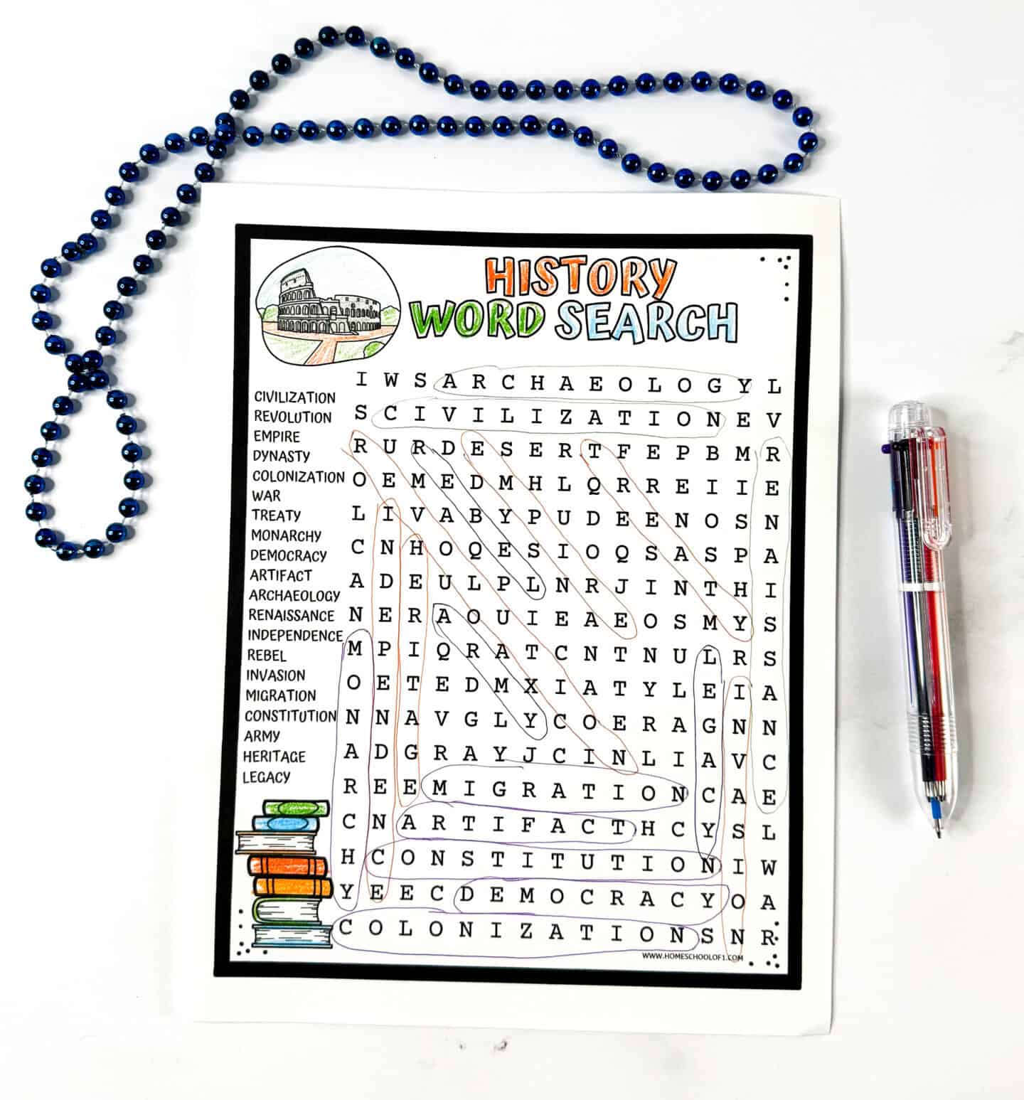 Free printable history word search puzzle for kids shown with pens and blue beads, featuring terms such as independence, empire, and archaeology.