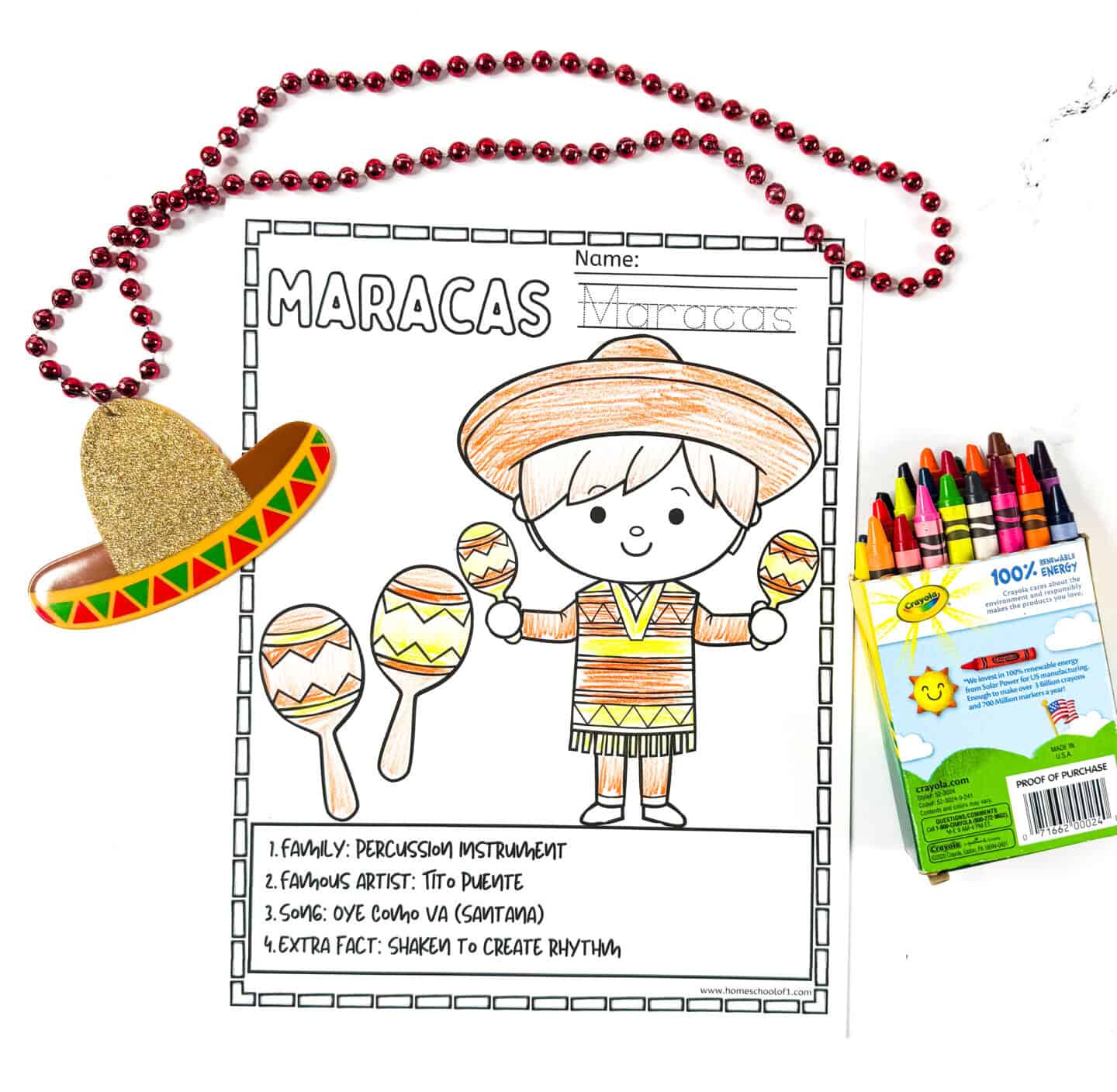 Maracas coloring page featuring a child in a sombrero and traditional clothing, partially colored with red beads and a glittery sombrero necklace.