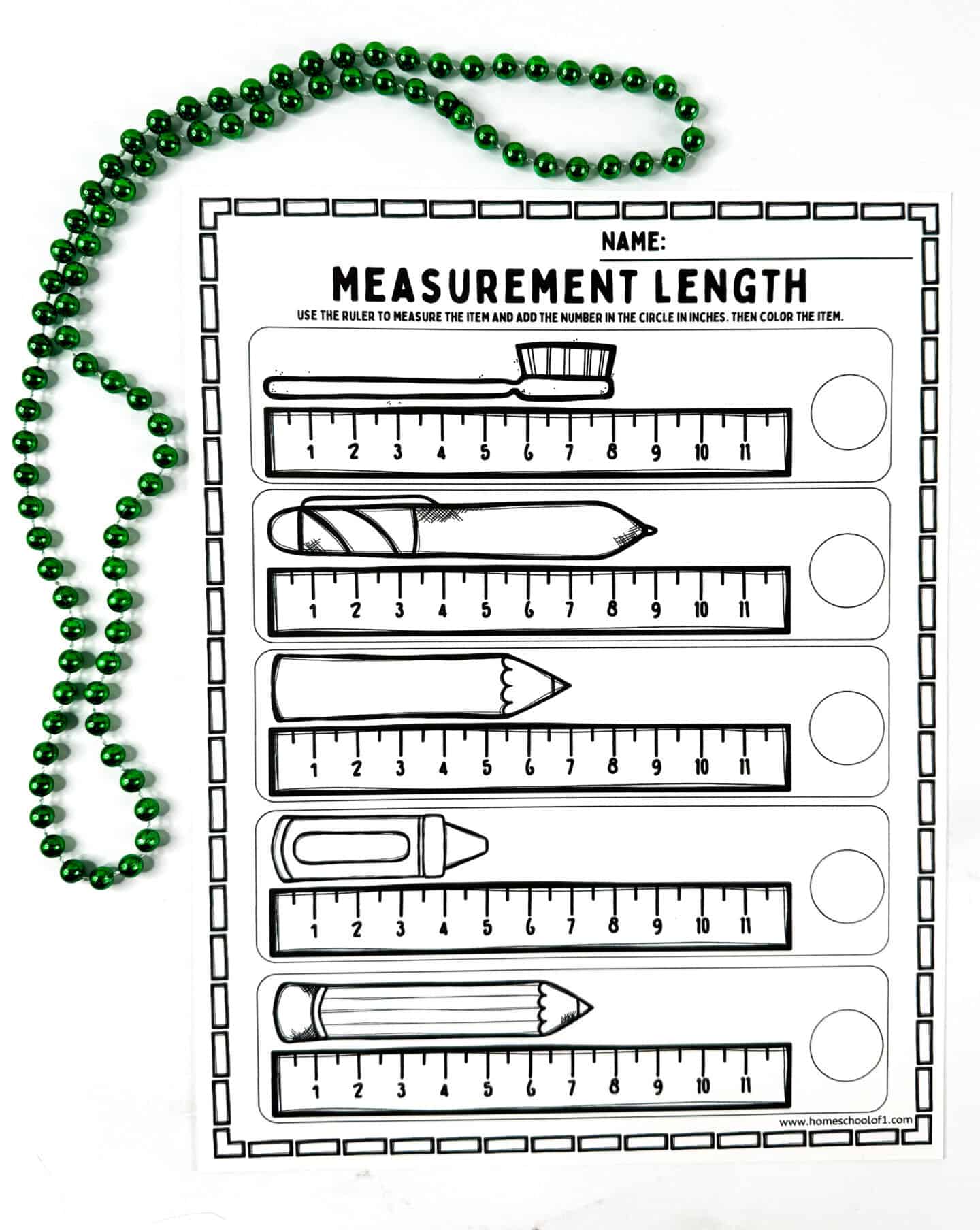 Black-and-white ruler measurement worksheet for children featuring drawings of a toothbrush, pencil, and crayon with inch rulers and a green bead border.