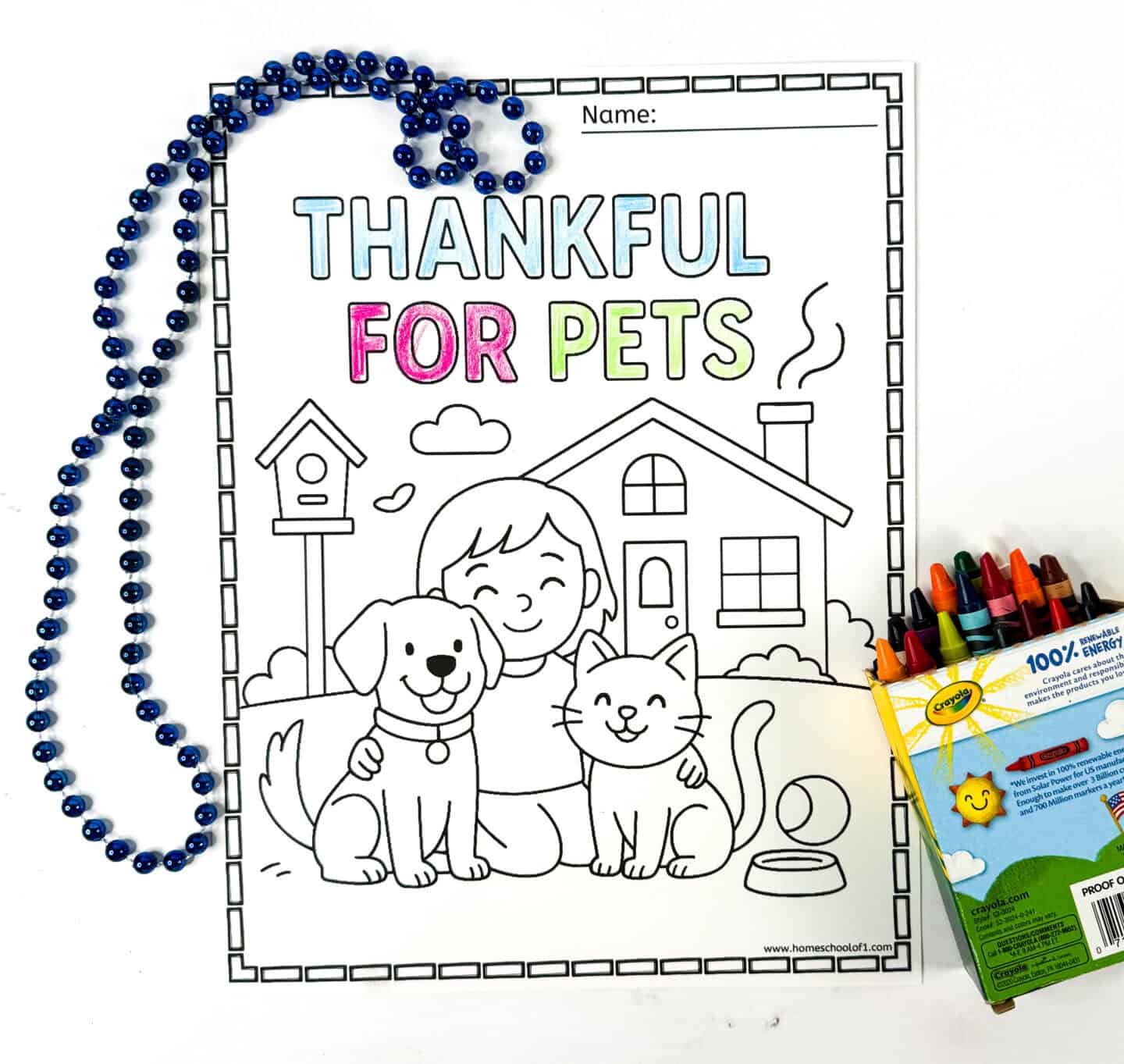 Printable thankful for pets coloring page with a child hugging a dog and cat in front of their house and a birdhouse nearby.